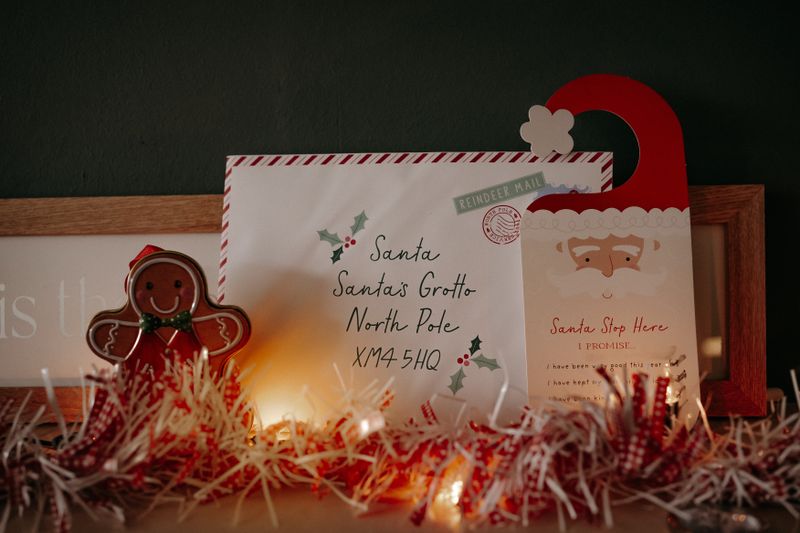 A cozy Christmas scene with a letter to Santa, gingerbread man, and warm decorative lighting.